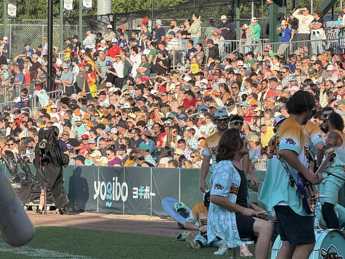A packed ballpark crowd behind Yogibo signage