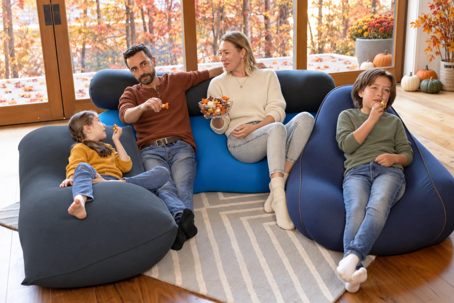 A family sharing fall snacks on Yogibo bean bags in a cozy autumn living room