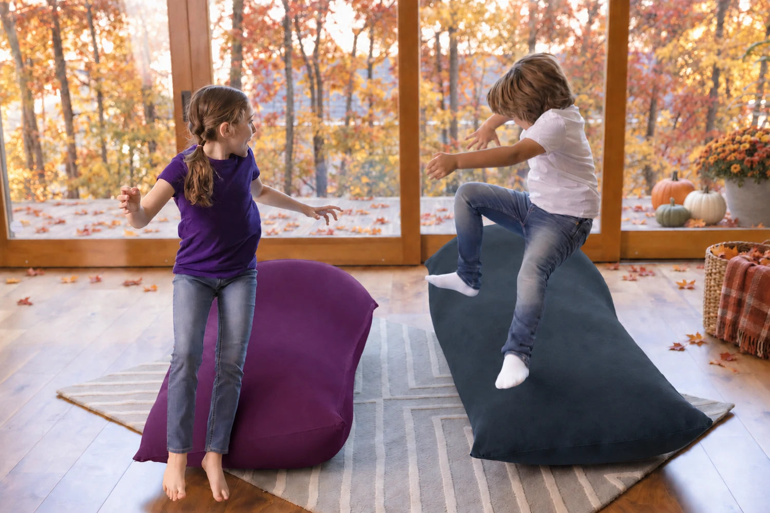 Two kids jumping and playing on Yogibo Max bean bags in a cozy fall room