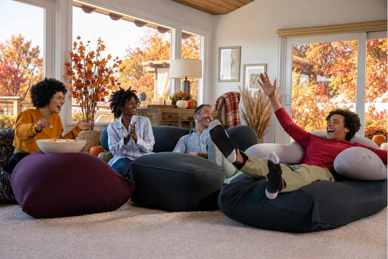 Friends laughing together on Yogibo bean bags in a cozy fall living room